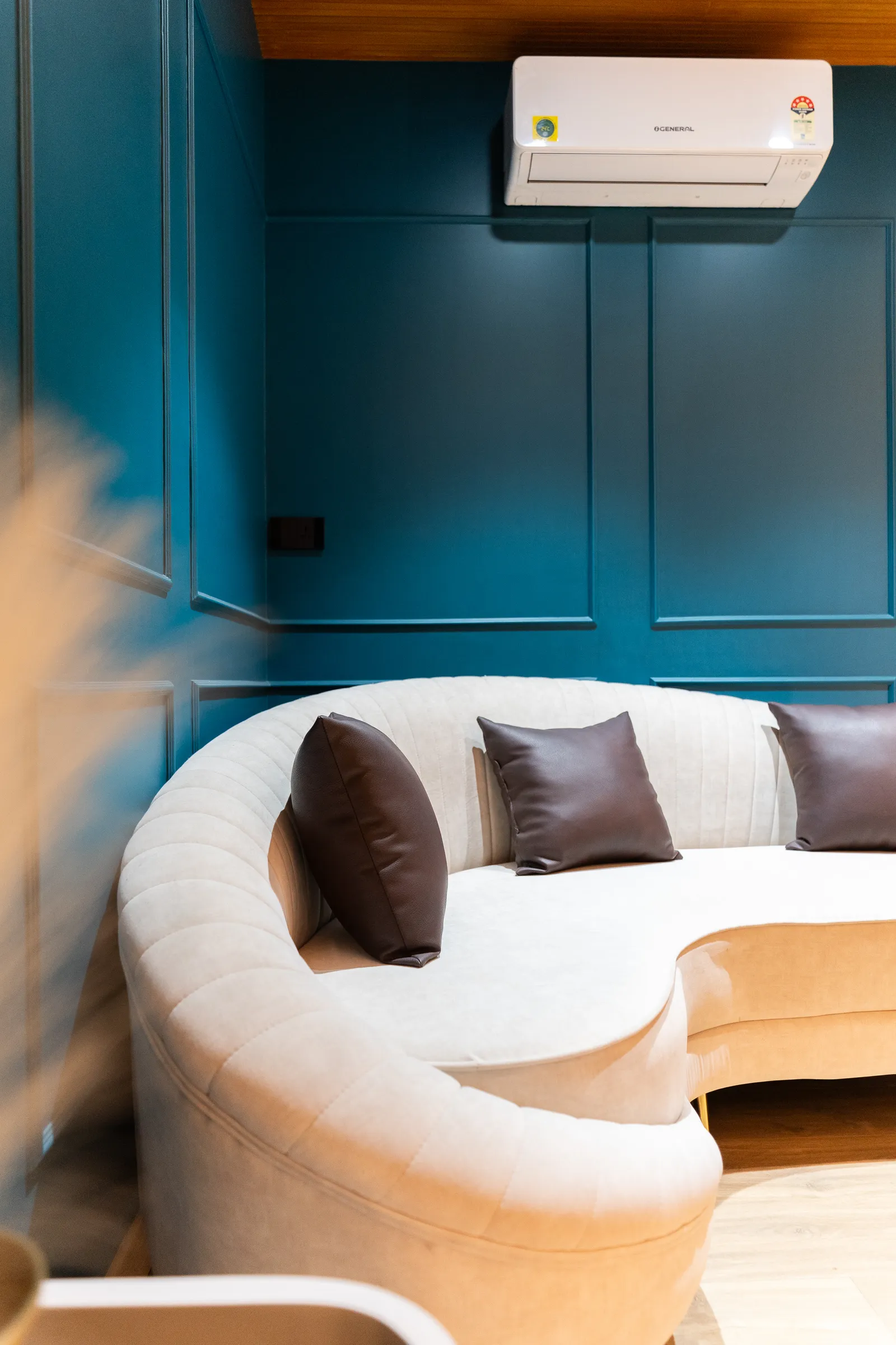 Curved sofa in the teal-panelled bedroom lounge — Abhishek's Residence